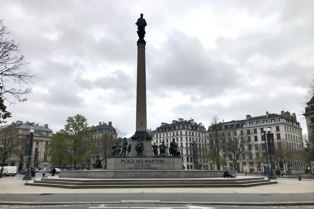 Monument commémoratif central entouré de bâtiments historiques