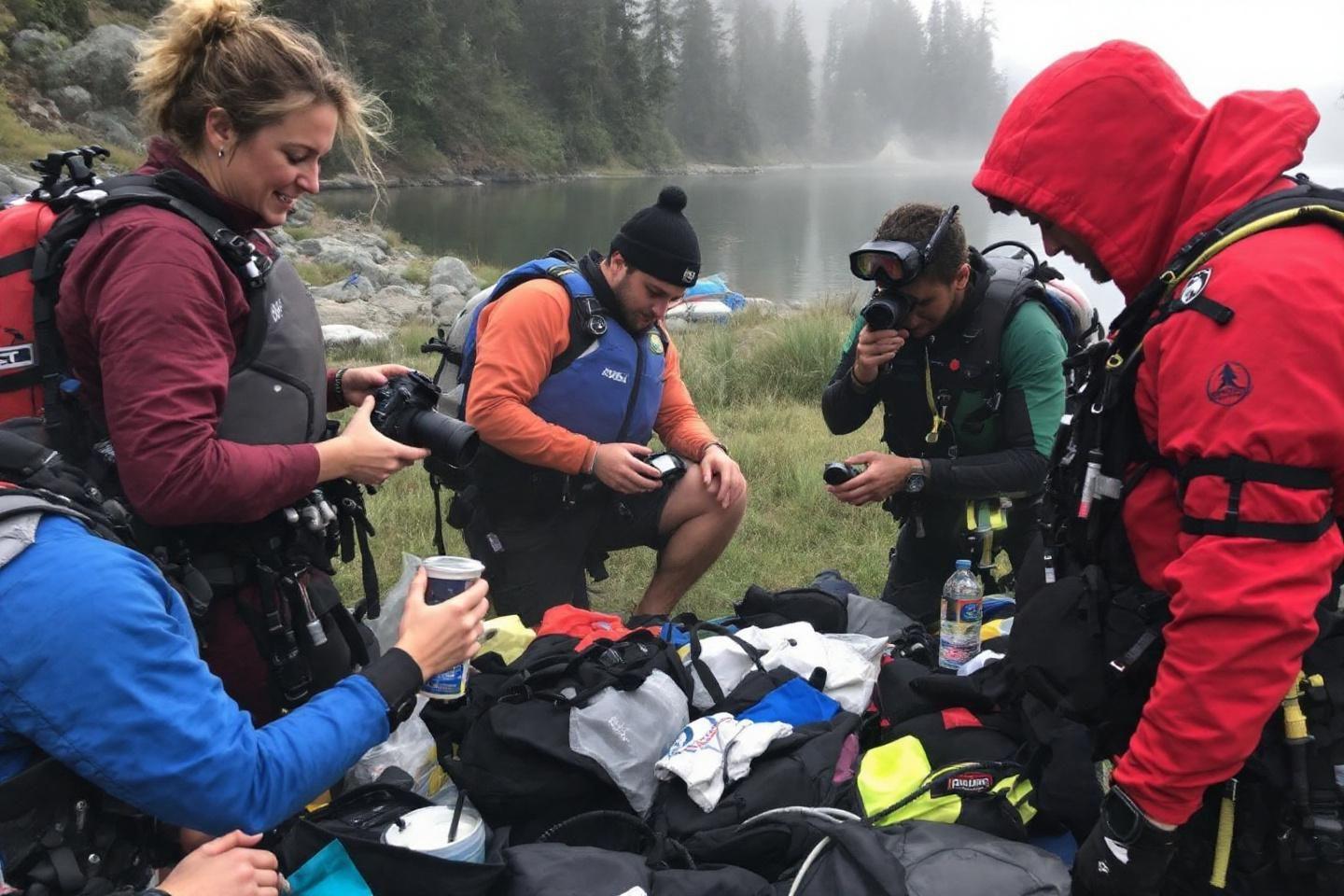 Groupe d'aventuriers en tenue outdoor autour de leurs équipements