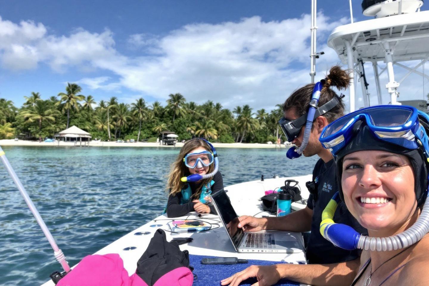 Équipe avec équipement de plongée sur un bateau près d'une plage